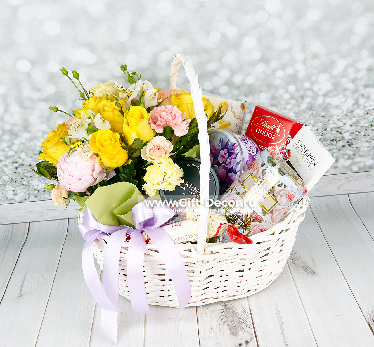 Подарочная корзина «Нежность» со сладостями и цветами: конфеты Lindor, шоколад, чай Basilure, композиция из роз, диантусов и альстромерии в кашпо.